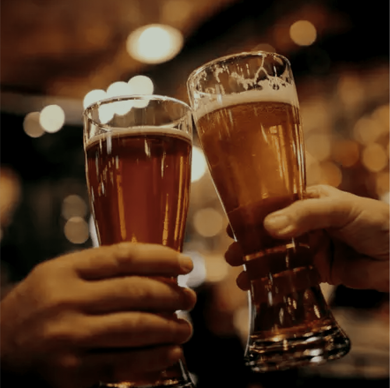 Two lager beer glasses toasting together